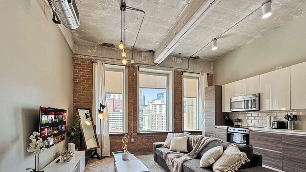 A modern apartment with a living room, kitchen, and large windows.