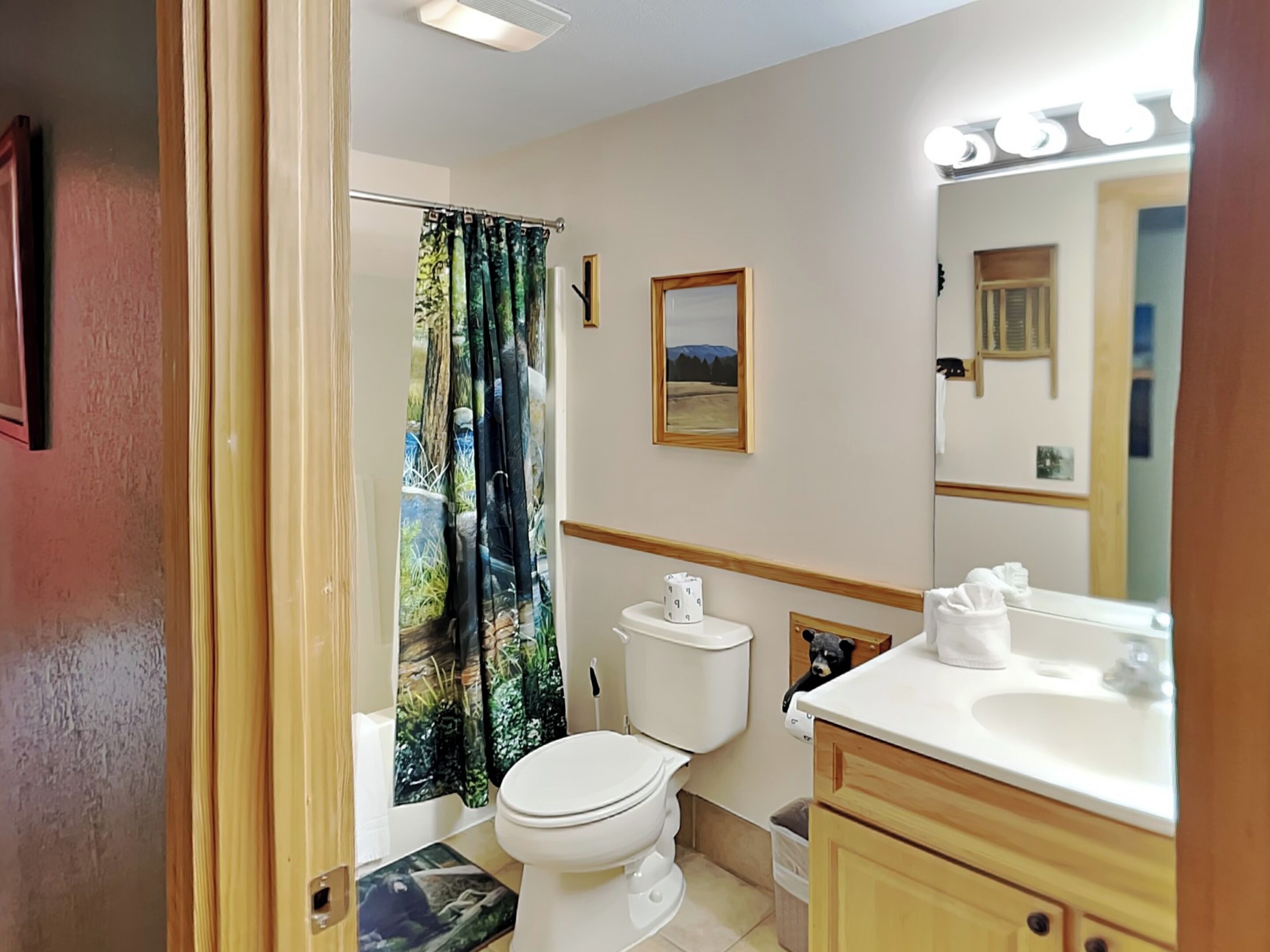 Un baño con inodoro, lavamanos y cortina de ducha.