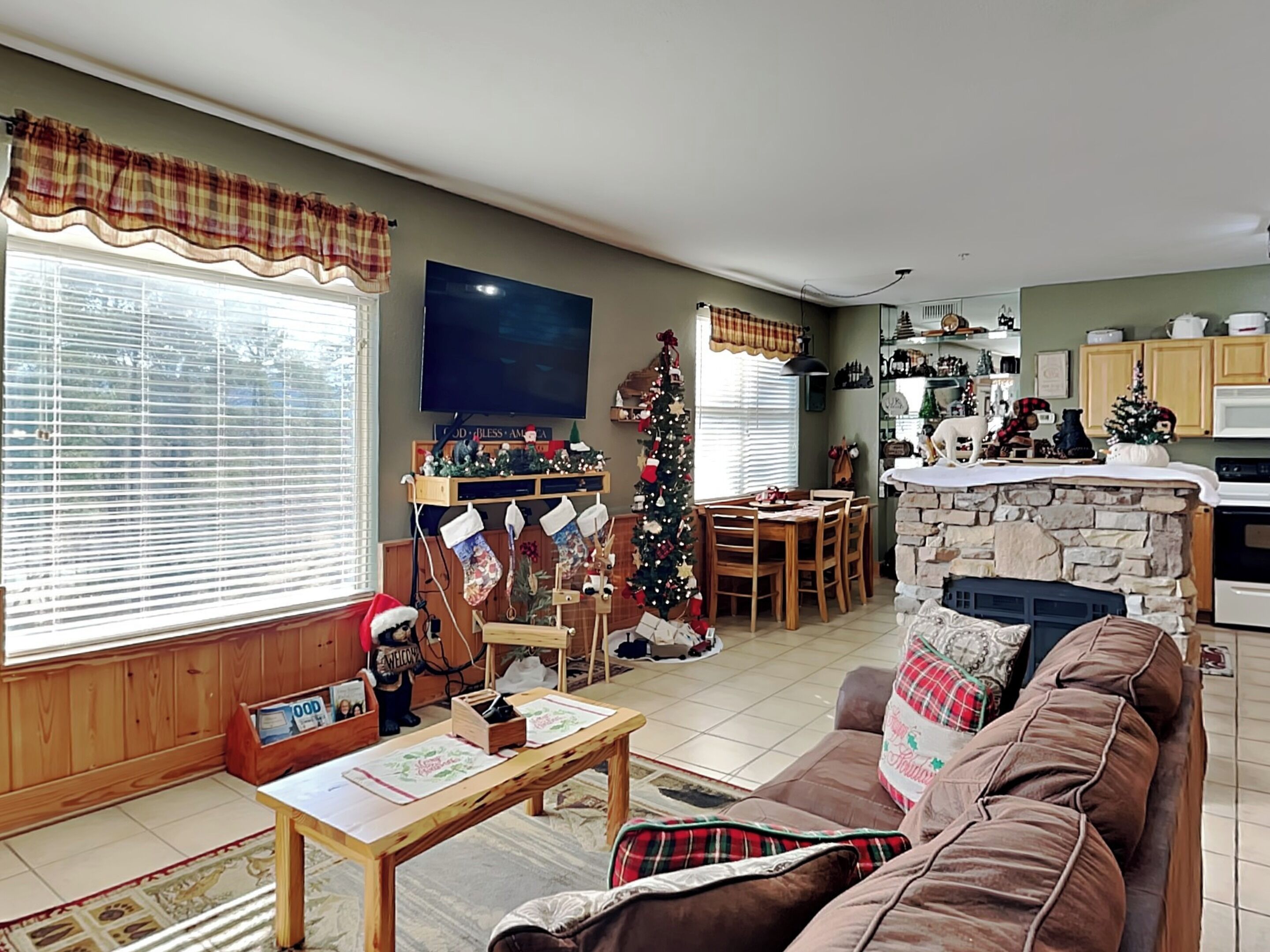 A cozy living room with a fireplace, a dining area, and a kitchen.
