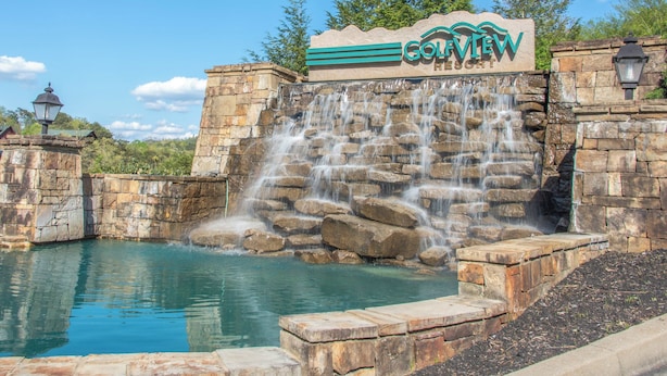 Une enseigne indiquant l’emplacement du Golview Resort, avec une cascade et une piscine.