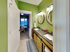 A bathroom with two sinks, a vanity, and a large mirror. - 5 Solas Lodge by Jackson Mountain Rentals (Sevierville)