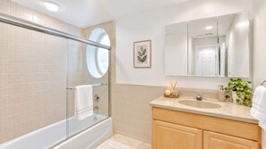 A modern bathroom with a glass-enclosed shower, a vanity with a sink, and a large mirror. - Luxury 2BD | Sleeps 12 | Chic Rittenhouse Retreat (Philadelphia)