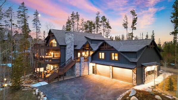 A multi-story log cabin with a stone facade, a second-story balcony, and a garage. - Winterhaven Estate by Avantstay Sleeps 19 Guests Mountain Compound w/ Views, Firepit, Hot Tub (Winter Park)