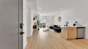 A modern apartment with a kitchen, dining area, and living room.