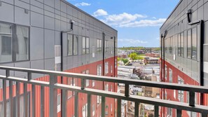 A modern building with large windows and a balcony railing.