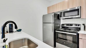 A modern kitchen with stainless steel appliances, a built-in oven, and a microwave.