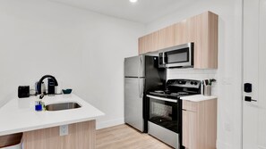 A modern kitchen with a stainless steel refrigerator, microwave, and stove.
