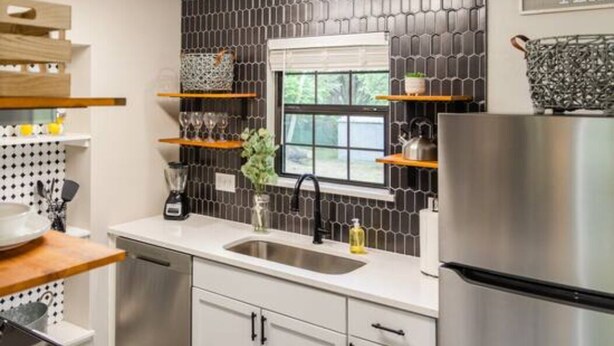 A modern kitchen with a stainless steel refrigerator, a window with a view, and a backsplash with a geometric pattern. - Canyon Lake Retreat by The Key Rentals (Canyon Lake)