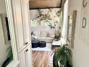 A cozy living room with a sofa, a coffee table, and a large plant. - The Nest · Sun-Drenched Loft · Private · Walk to Everything (Los Alamos)