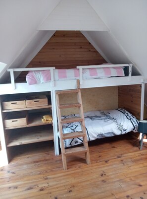 A loft-style bedroom with a wooden ladder leading to a bunk bed, a desk with drawers, and a bed with patterned bedding. - Seaside house.  On the GR 34, 8 minutes from two beaches, " (Penvenan)