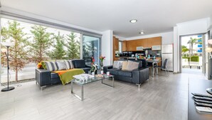 Un salon moderne avec un canapé, une table basse et une vue sur la cuisine.