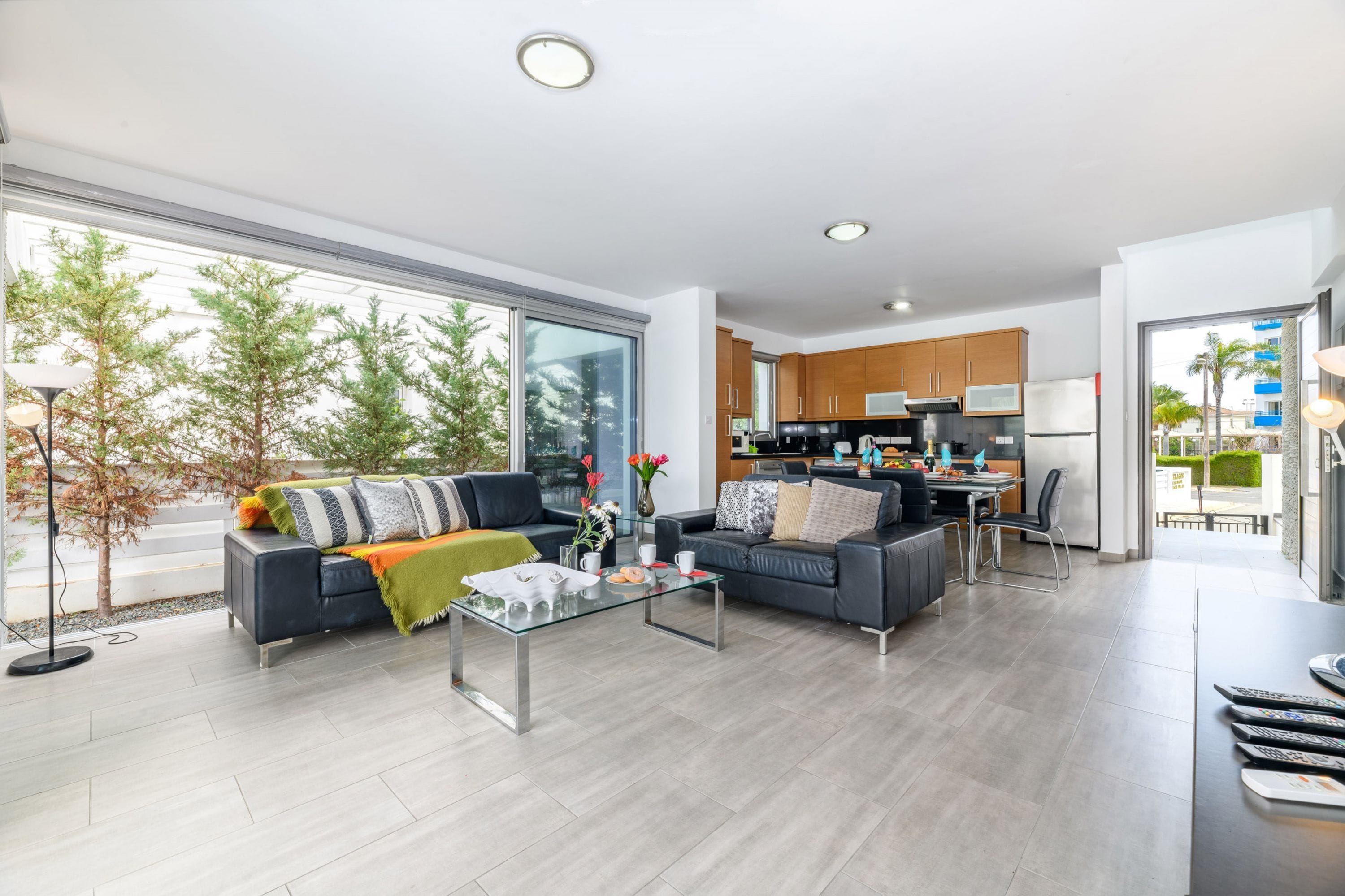 A modern living room with a sofa, coffee table, and a view of the kitchen.