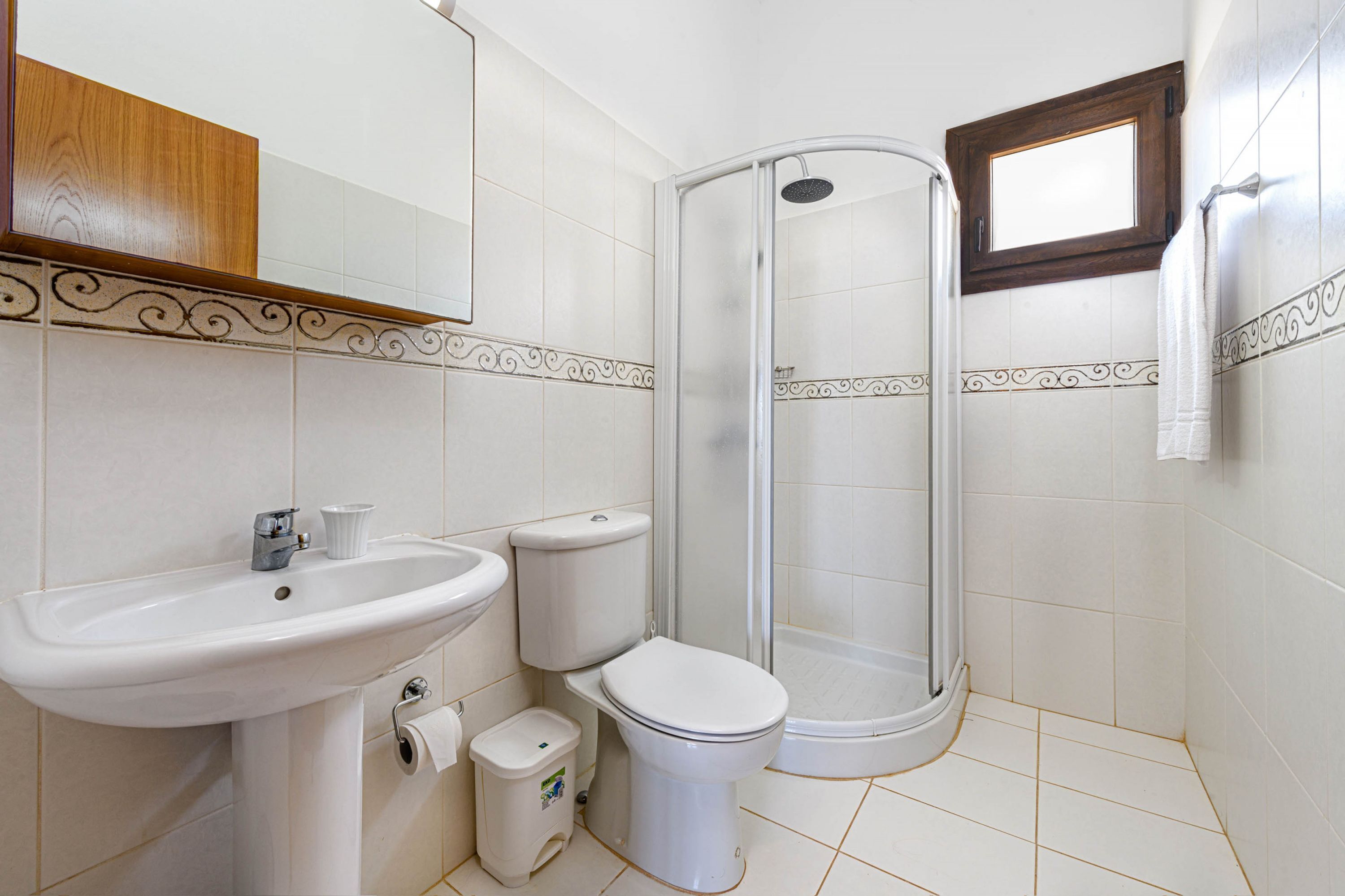 Une salle de bain équipée d’un lavabo, de toilettes et d’une douche à parois en verre.