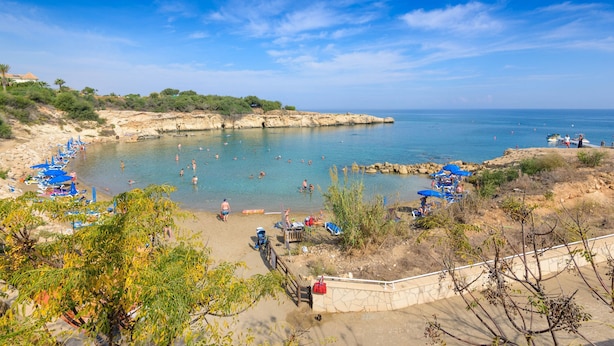 Une plage à l’eau d’un bleu cristallin, où l’on peut se baigner et prendre des bains de soleil, et une côte rocheuse.