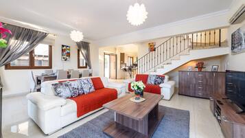A modern living room with a sofa set, a coffee table, and a TV stand.