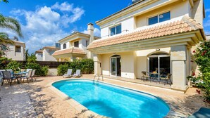 A residential property with a swimming pool, outdoor seating, and a tiled roof. - Villa Oscar in Protaras (Paralimni)