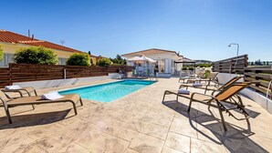 A rooftop pool area with lounge chairs, a covered seating area, and a clear view of the surrounding landscape. - Sunset Villa in Protaras (Paralimni)