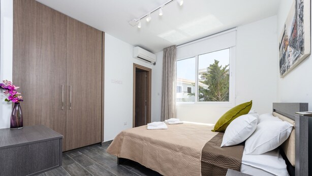 Quarto de hotel moderno com uma cama, uma escrivaninha e um guarda-roupa.