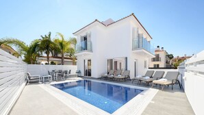 A modern two-story house with a swimming pool, outdoor seating, and a white exterior. - Villa Elaine in Protaras (Paralimni)