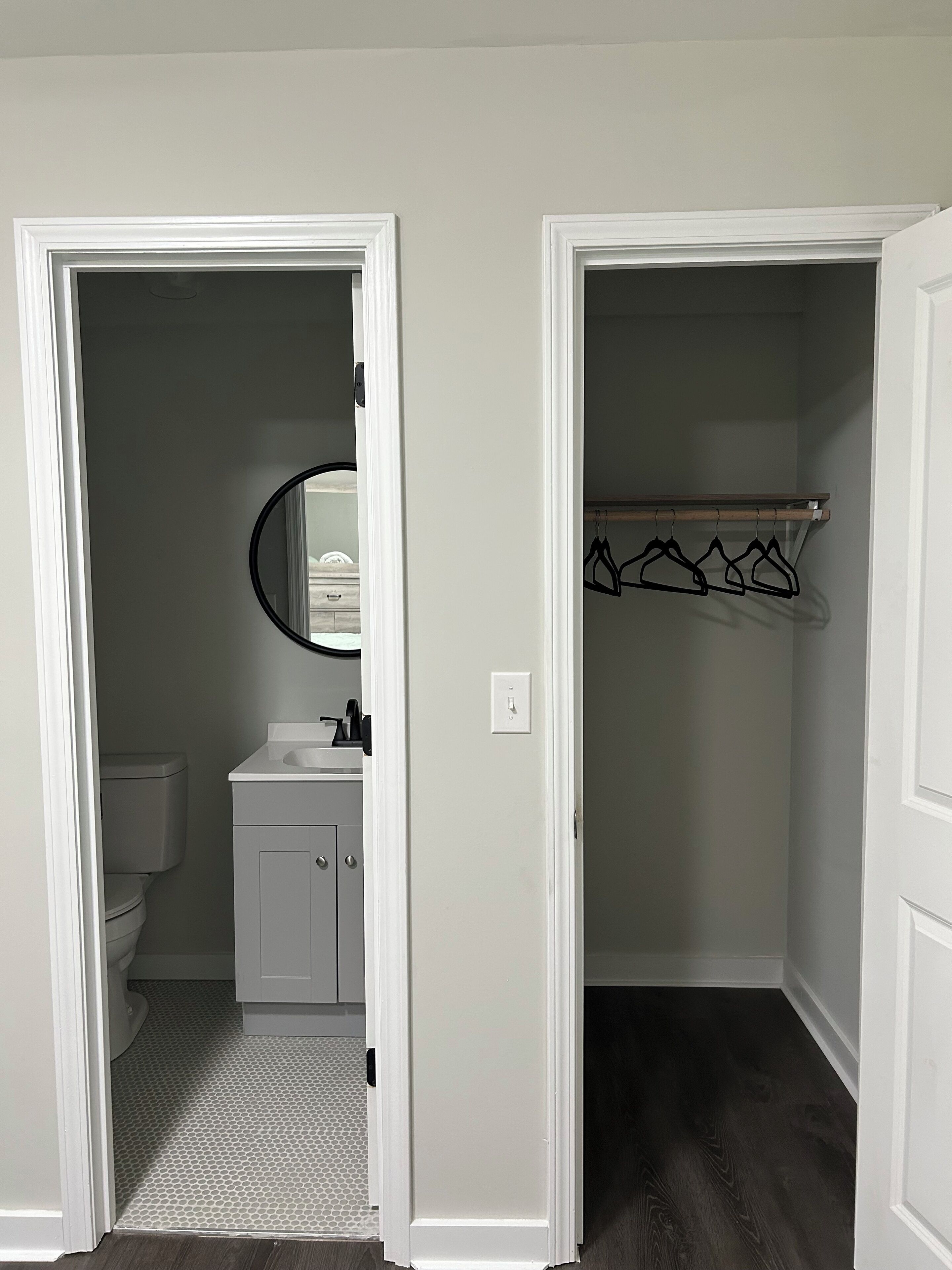 A bathroom with a toilet, sink, and mirror.