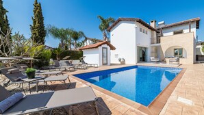 Eine moderne Villa mit Swimmingpool, Außenbereich und einem gepflegten Garten.