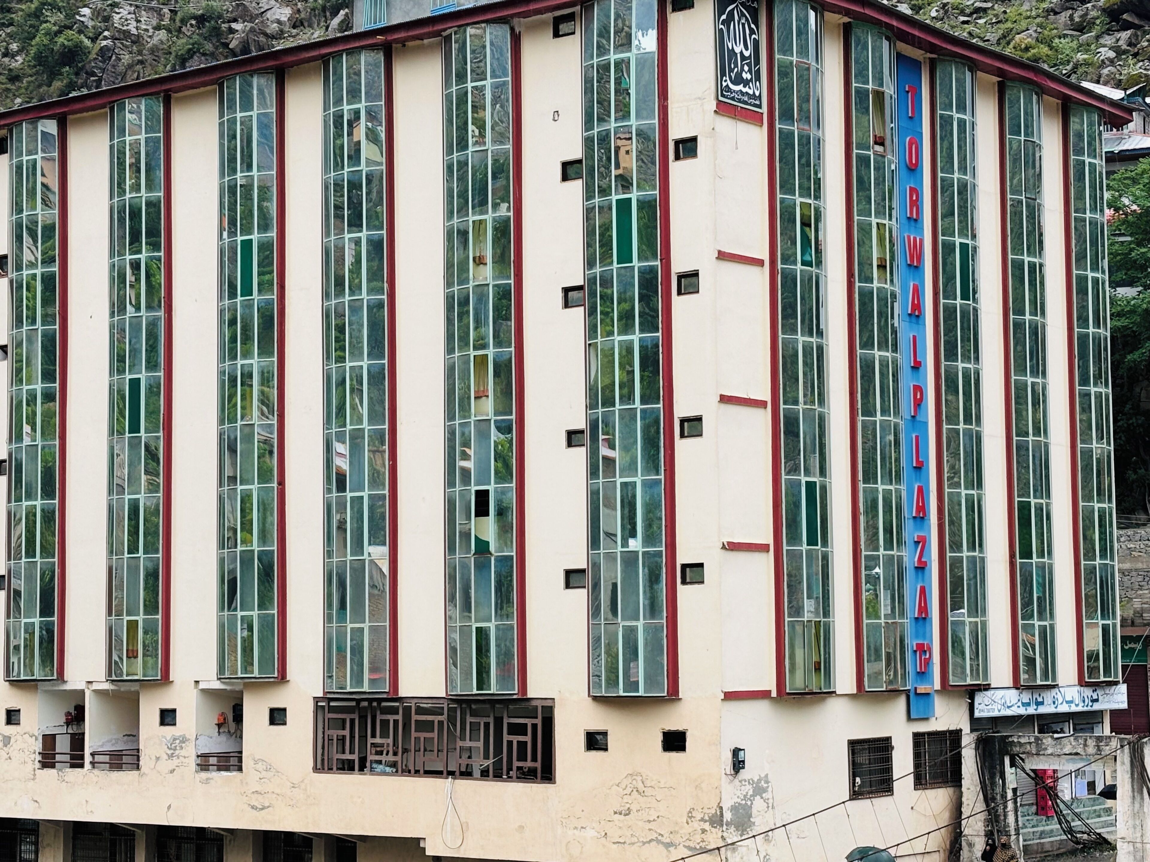 A building with large windows and a sign reading "TORALPLAZ".