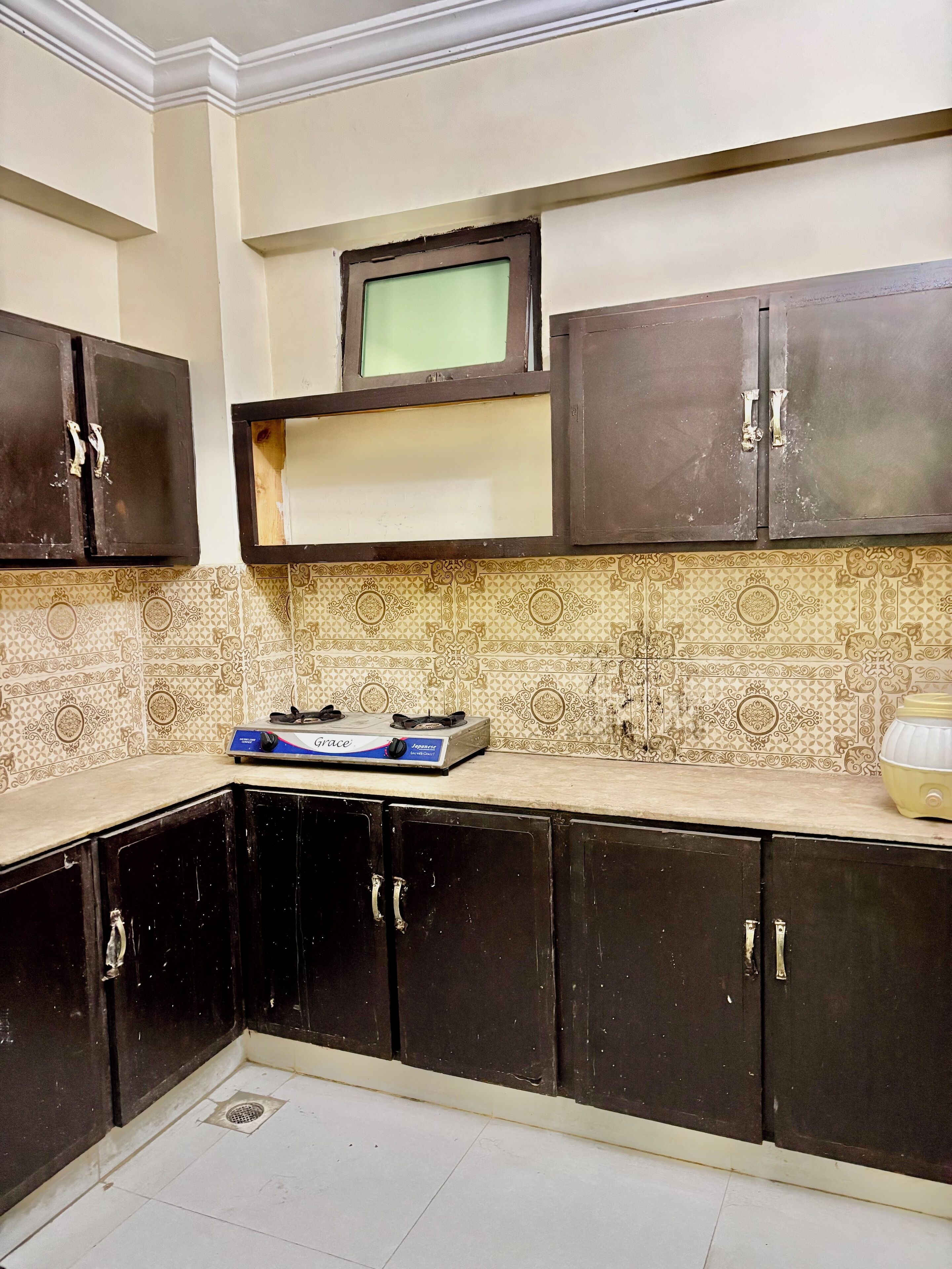 A kitchen with dark cabinets, a gas stove, and patterned tiles.