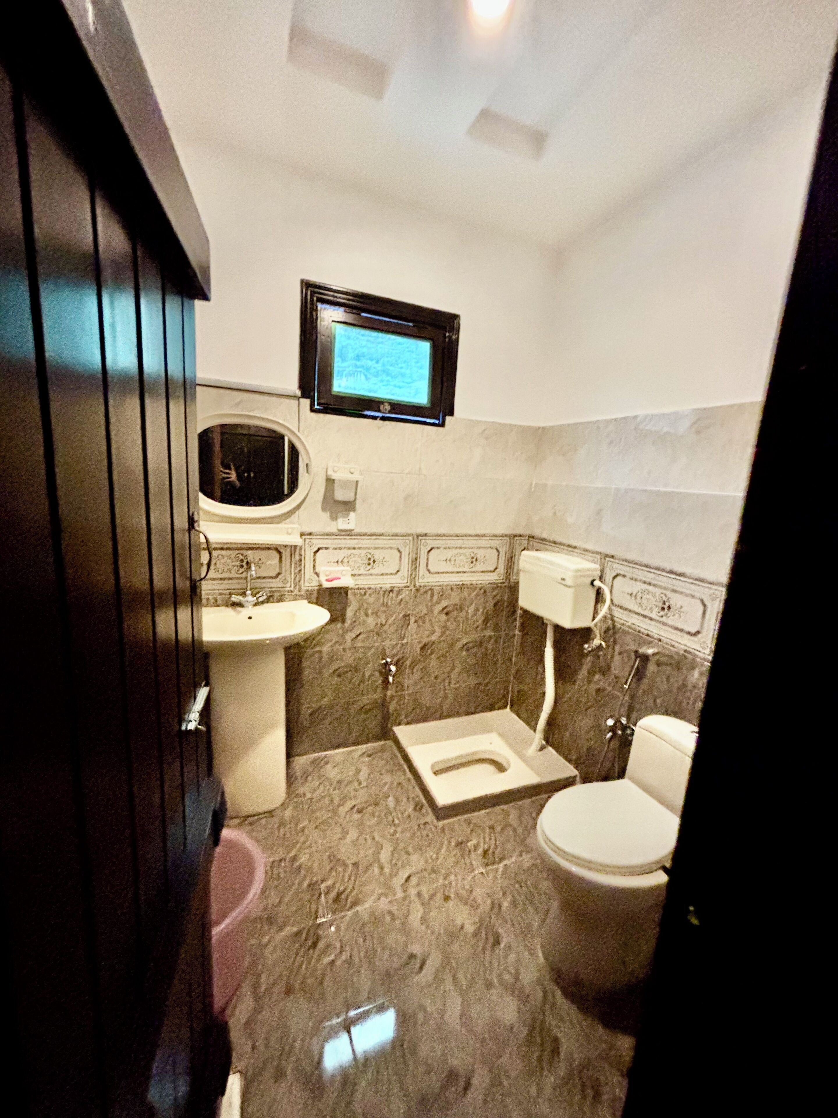 Un baño con inodoro, lavamanos y espejo.