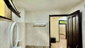 A bathroom with a sink, mirror, and a door leading to another room.