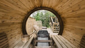 A circular wooden sauna with a wooden bench and a wooden chair. - All Season Muskoka Cottage*HotTub*Sauna*Beach*BBQ (Huntsville)