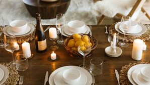 A dining area with a wooden table set for a meal, surrounded by chairs. - Fox Den|Sauna|BBQ|LakeAccess|PrivateBeach|Firepit (Huntsville)
