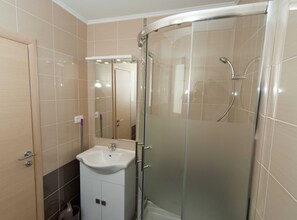 A modern bathroom with a glass shower enclosure, a white sink, and a mirror. - Beachfront Apartments for Relaxing Getaways in Crikvenica - Junior Studio Apartment 2 2 (Crikvenica)