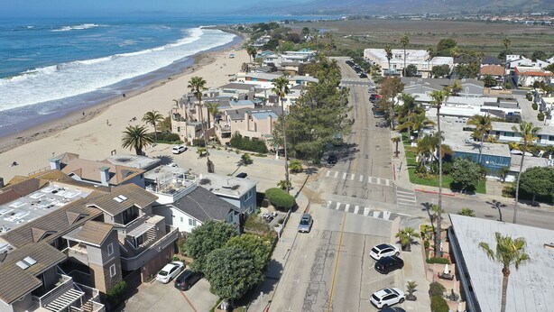 Eine Küstenwohngegend mit Strandhäusern, einer Hauptstraße und einem Strand.
