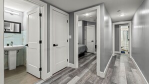 A hallway with a bathroom on the left, a bedroom in the middle, and a shower area on the right. - Serenity Stays Charming 3bd 2.5ba Oasis (Philadelphia)