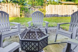 Eine Terrasse mit zwei Adirondack-Stühlen und einem schwarzen Laternentisch.