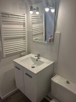 Ein Badezimmer mit Waschbecken, Spiegel und Toilette.