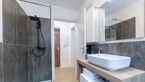 Une salle de bain moderne avec une douche, un grand lavabo et un miroir.