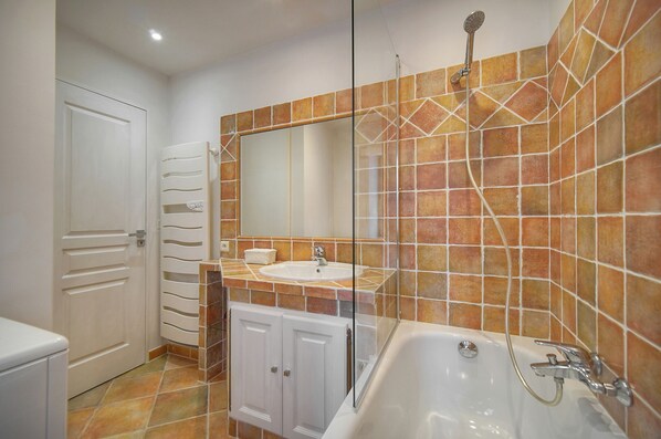 Une salle de bain avec une baignoire, un lavabo et une douche.
