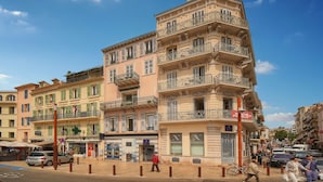 Un edificio de varios pisos con balcones, una tienda y una zona peatonal.
