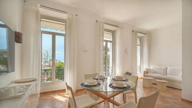 Un comedor con una mesa de vidrio, sillas y un sofá.