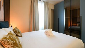 A hotel room with a large bed, a wardrobe, and a view through a glass door. - Torino | Red Oasi Apartment (Torino)