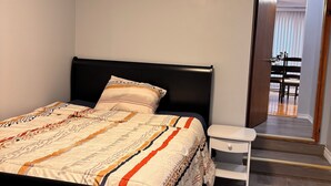 A bedroom with a bed, bedside table, and a view of a dining area through an open door. - A min walk to the zoo and University!2 bed apartment (Peterborough)