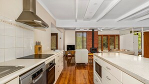 A modern kitchen with white cabinetry, a built-in stove, and a large island. - Sea Sounds on Lohr Inverloch (Inverloch)