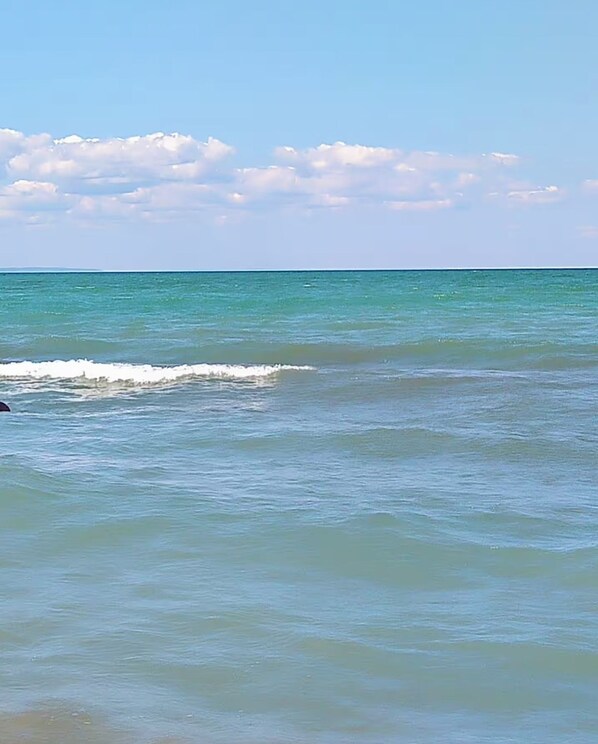 A calm sea with gentle waves and a clear sky.