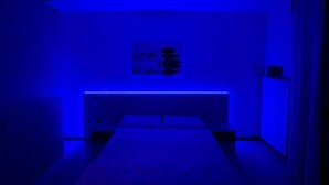 Une pièce comprenant un lit, une étagère fixée au mur et un ventilateur de plafond.