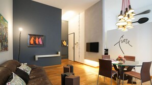 A modern living room with a brown leather sofa, a glass dining table with chairs, and artwork on the walls. - Milan Center | Garibaldi Center Apartment (Milano)