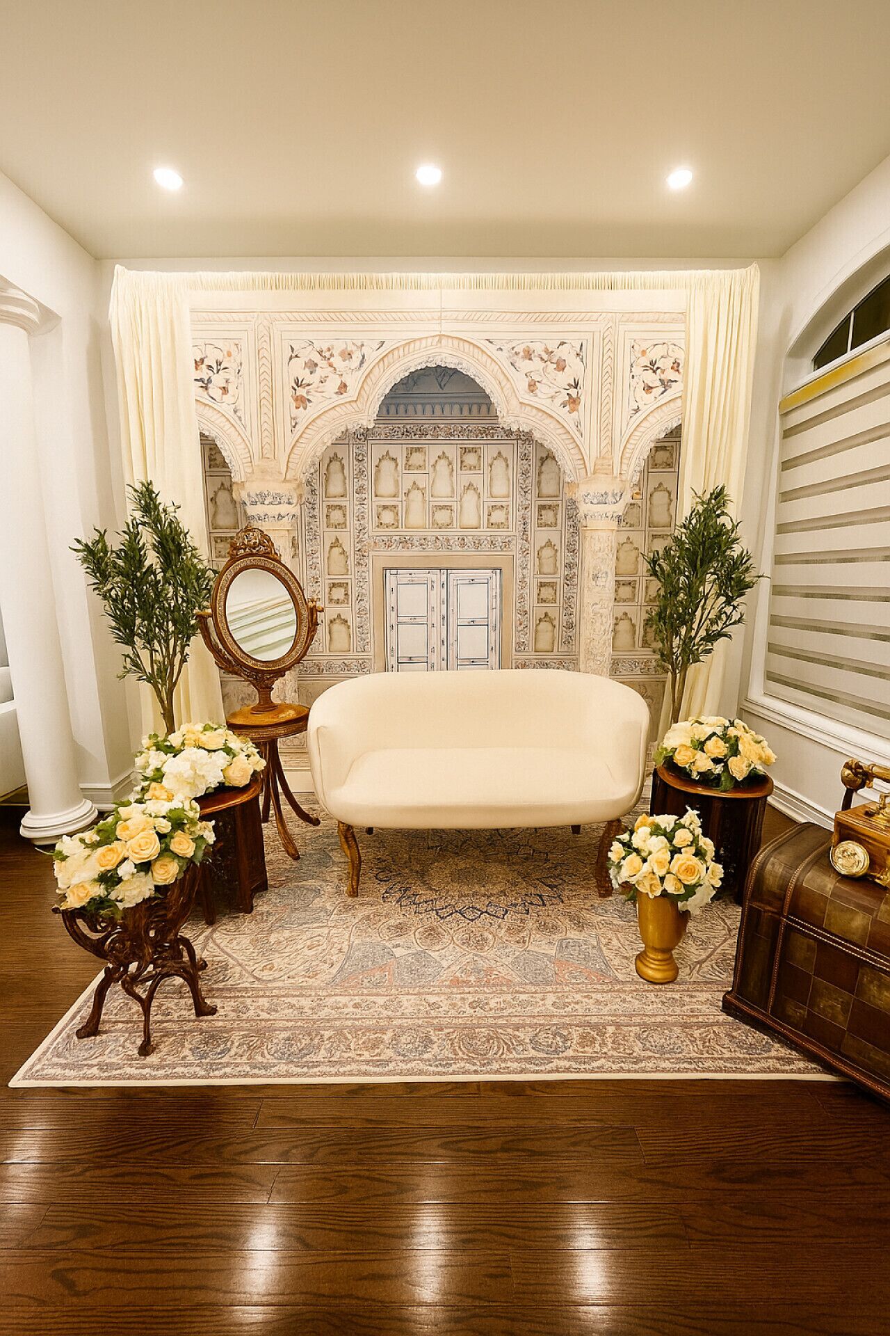 A room with a sofa, a mirror, and a decorative wall.