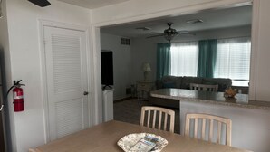 A dining area with a table, chairs, and a fire extinguisher. - Charming 2-bedroom apartment with AC, WiFi in delightful Wildwood Crest (Wildwood Crest)