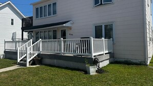 A two-story house with a front porch, a small deck, and a mailbox. - Charming 2-bedroom apartment with AC, WiFi in delightful Wildwood Crest (Wildwood Crest)