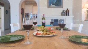 Un tavolo imbandito con piatti, bicchieri di vino rosso e diversi assaggi.